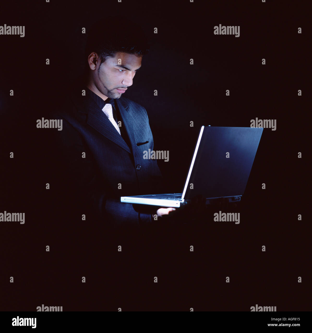 Businessman with laptop dans le noir Banque D'Images