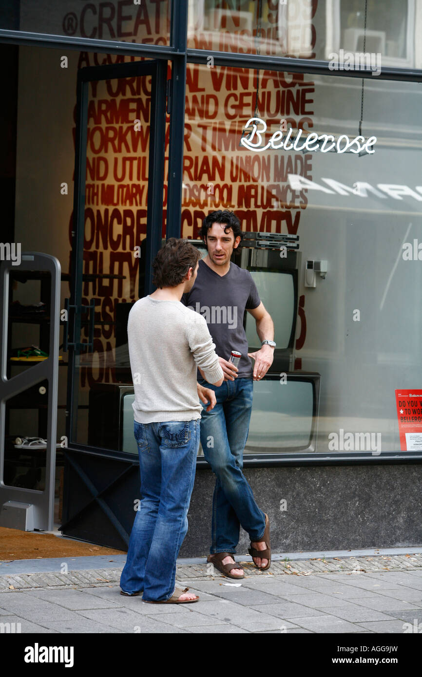 Hommes debout à l'extérieur d'une boutique sur une rue Utrechtsestraat avec ses boutiques et cafés Amsterdam Pays-Bas Banque D'Images