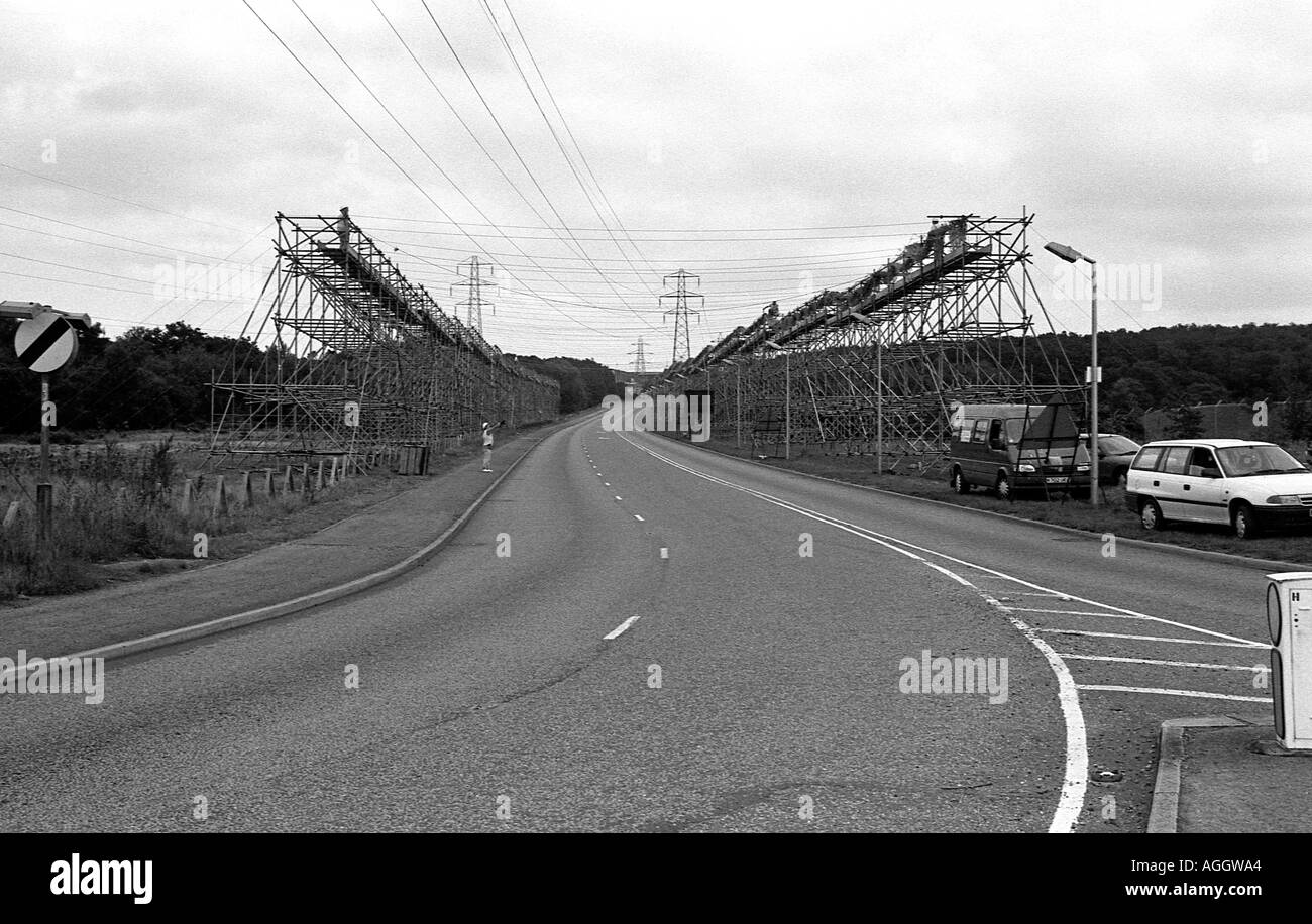 Chemin public délaissé d'échafaudages sur chaque côté pour protéger les automobilistes pendant les travaux sur les lignes électriques à haute tension Banque D'Images