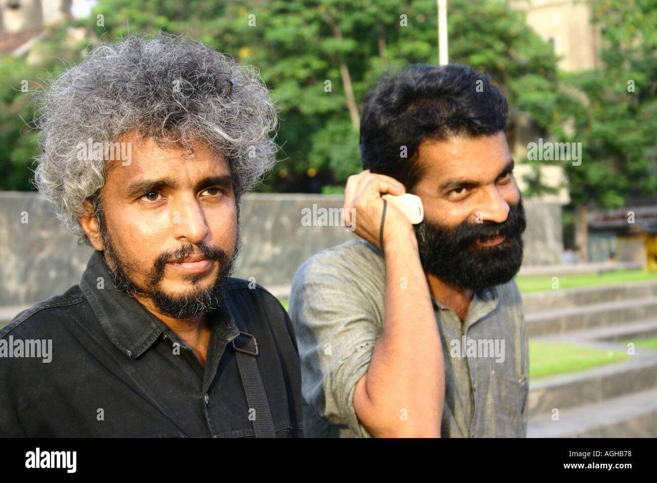 Artiste indien Surendra Rao en cheveux gris et dans Vajpai Avadhesh barbe noire talking on mobile phone Bombay Mumbai Inde Banque D'Images