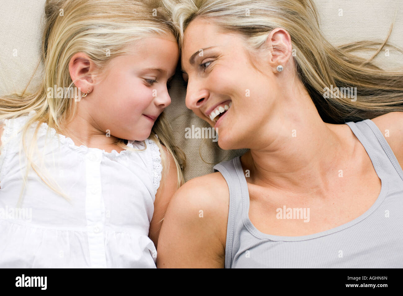 Mère et fille couchée smiling at eachother Banque D'Images