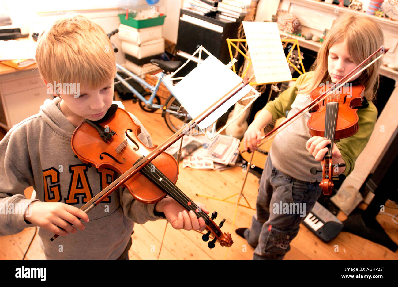 Un frère et une soeur ne leur pratique quotidienne violon dans une famille anglaise typique de classe moyenne de séjour Banque D'Images