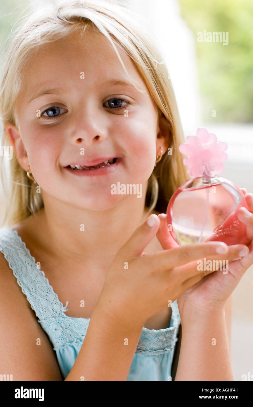 Petite fille tenant une bouteille de parfum pour enfant Banque D'Images