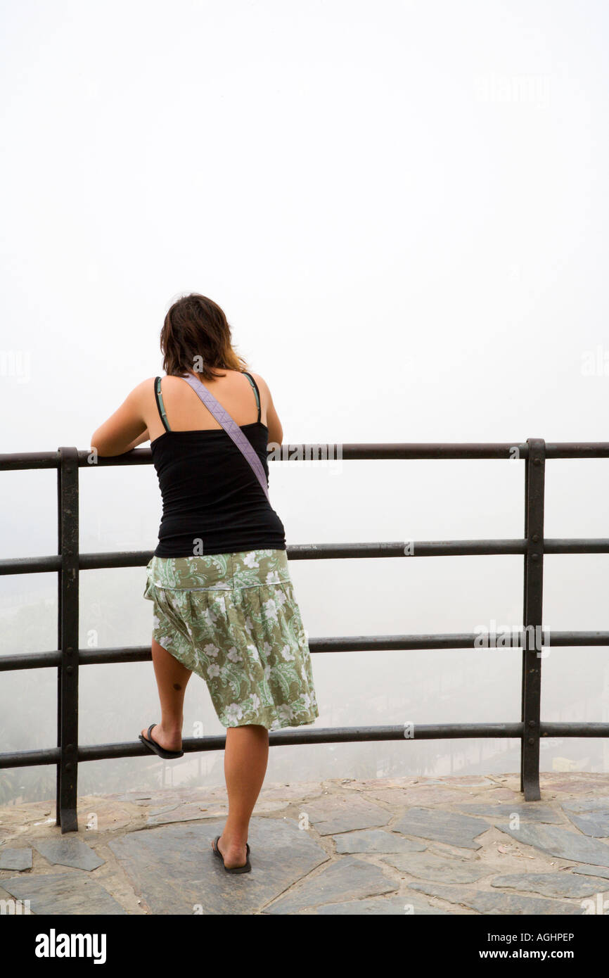 Femme à la recherche dans la brume du belvédère sur la Colline Gibralfaro Malaga Espagne Banque D'Images