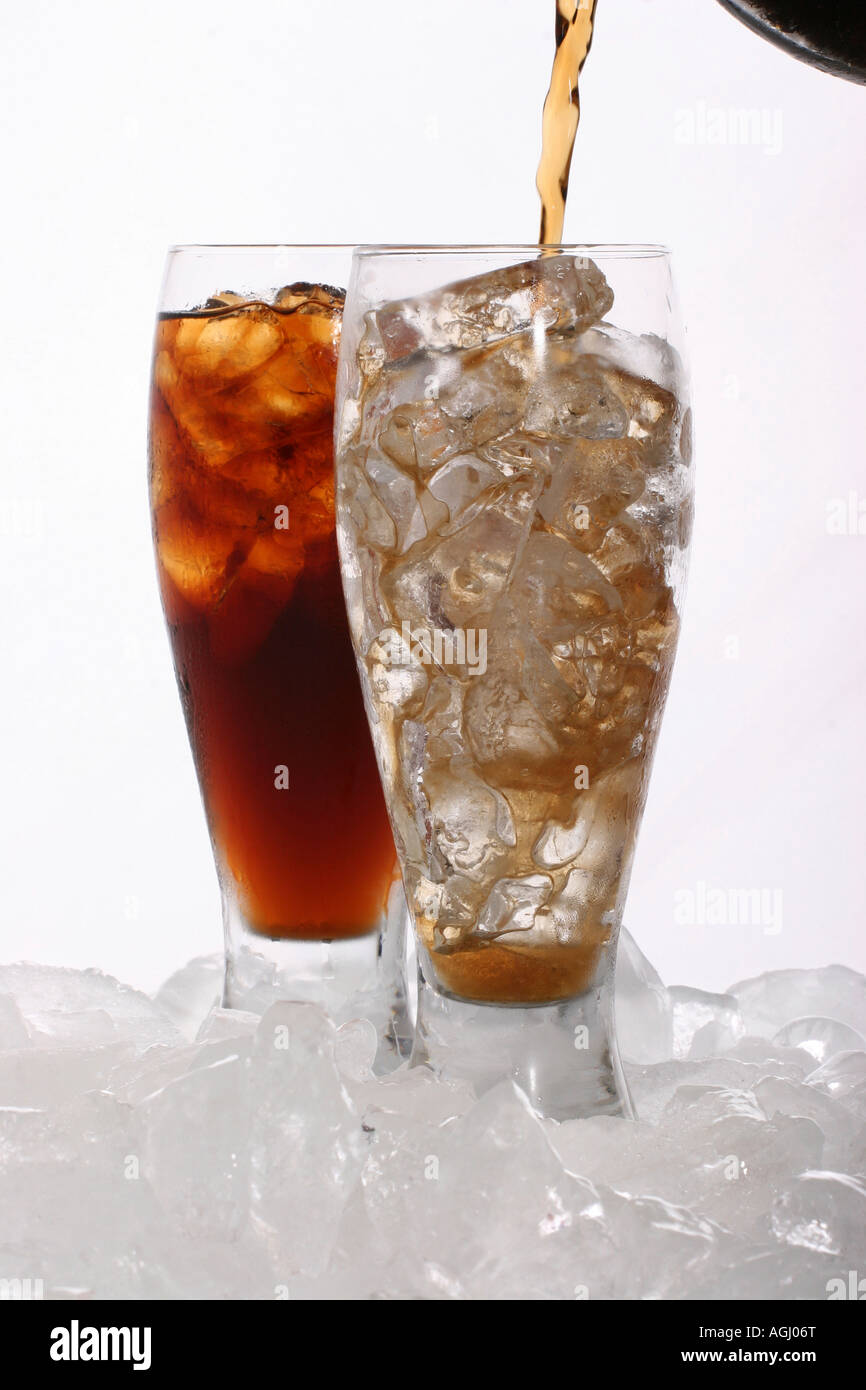 Verser une boisson Coca Cola dans un verre avec des glaçons boisson sur fond de table blanc Coca boisson personne marque boissons gazeuses haute résolution verticale Banque D'Images