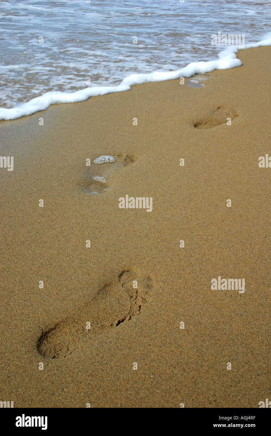 Empreintes de pieds disparaissant dans la mer sur plage de Doogort sur Achill Island, comté de Mayo, République d'Irlande Banque D'Images