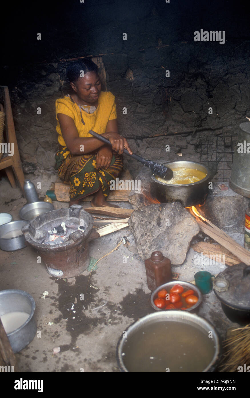 Femme à la cuisson des aliments sur un poêle traditionnel, Morogoro, Tanzanie Banque D'Images