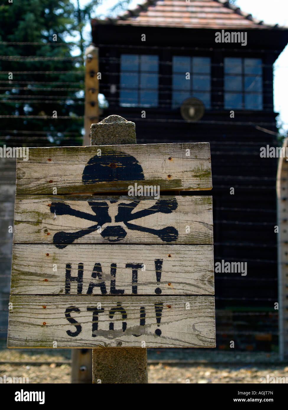 Barbelés et "Halt !" panneau d'avertissement avec joue au camp de concentration d'Auschwitz à l'extérieur de Cracovie, Pologne Banque D'Images