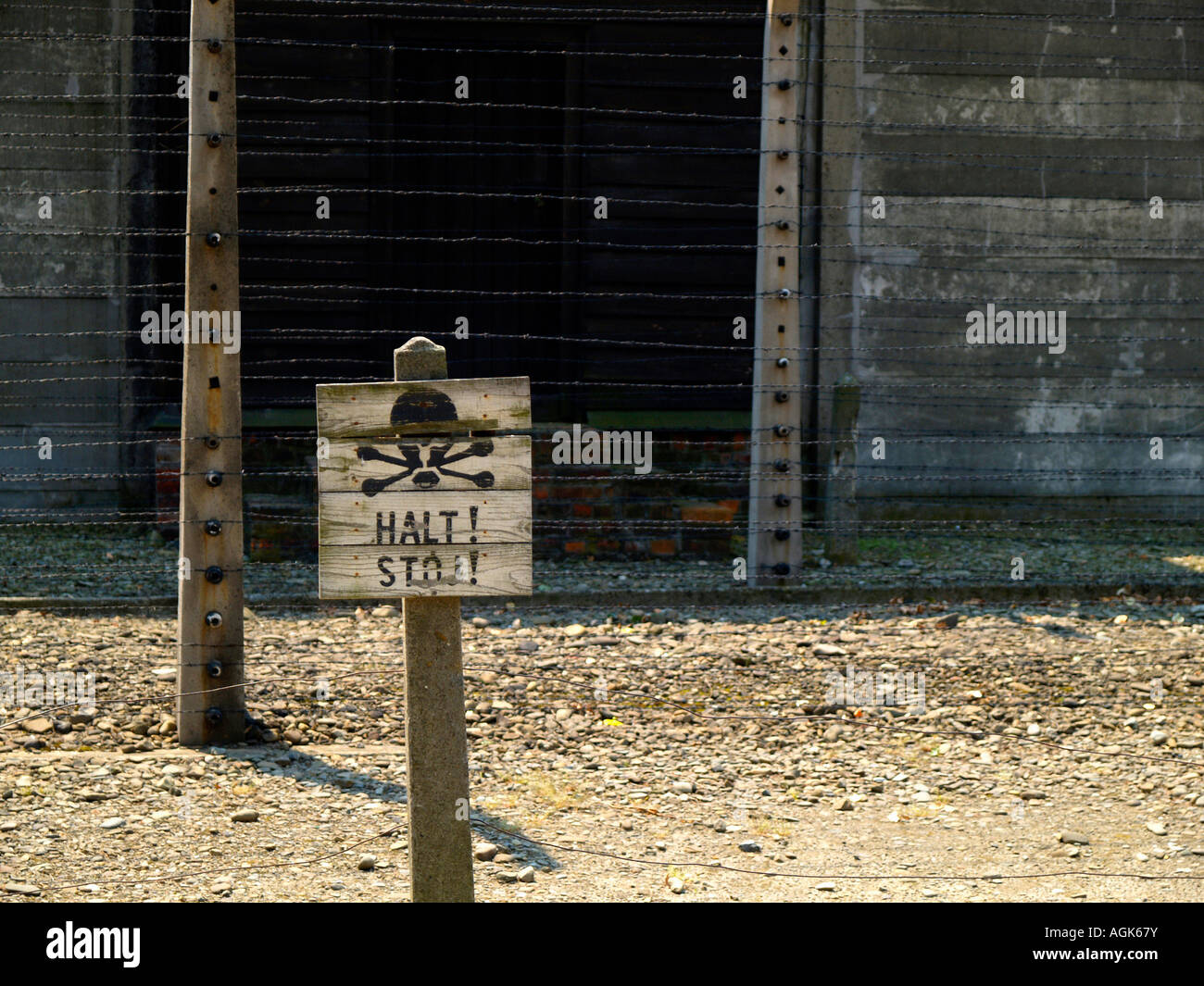 Barbelés et "Halt !" panneau d'avertissement avec joue au camp de concentration d'Auschwitz à l'extérieur de Cracovie, Pologne Banque D'Images