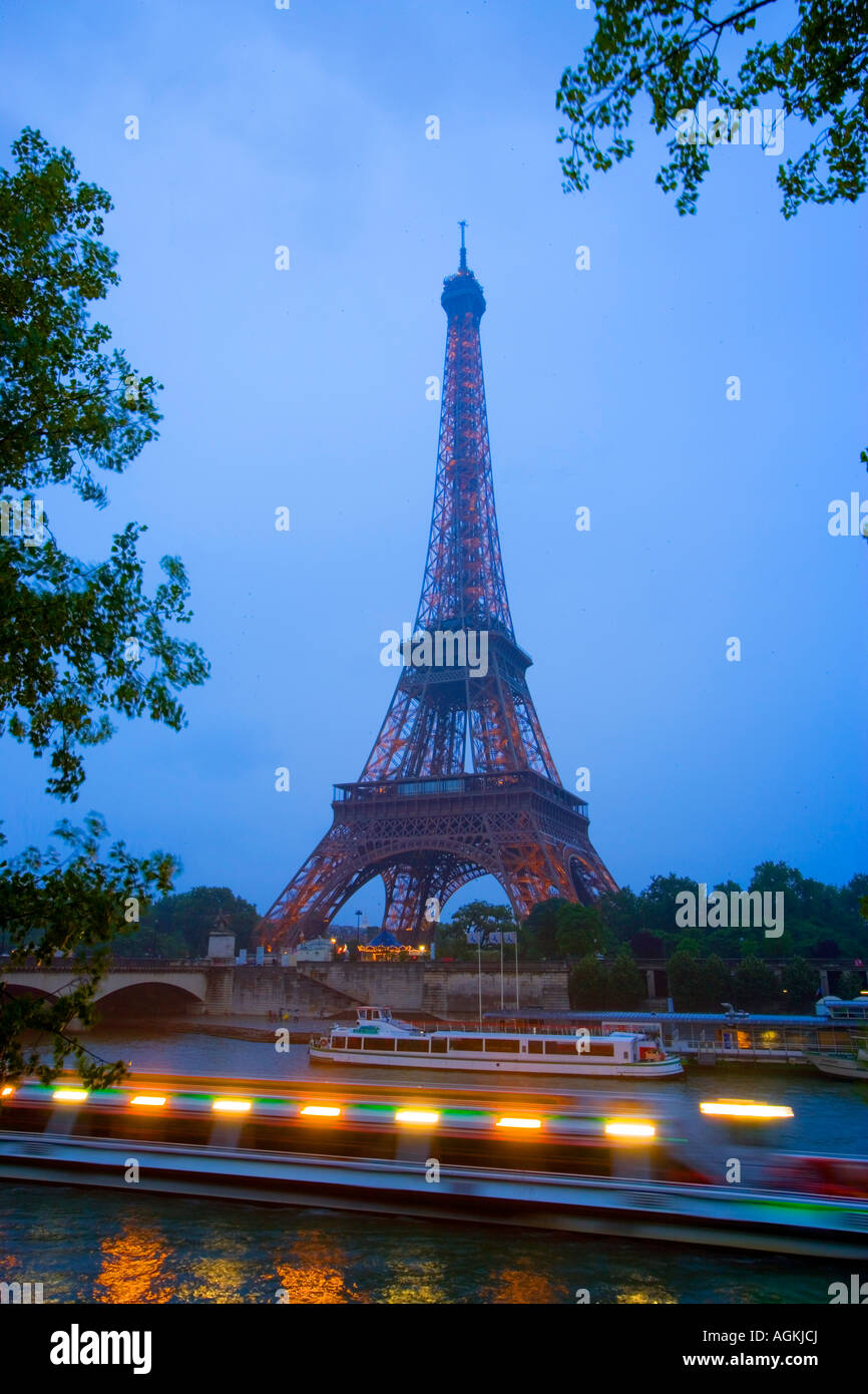 Europe, France, Paris. En début de soirée de voir la Tour Eiffel et les bateaux d'excursion sur la Seine. Banque D'Images