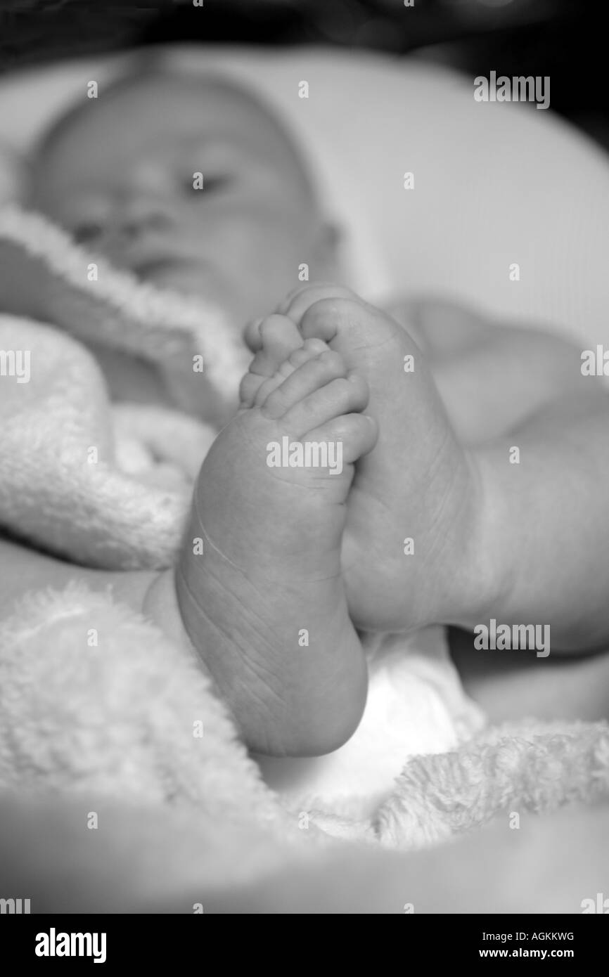 Les pieds et le visage de bébé Banque D'Images