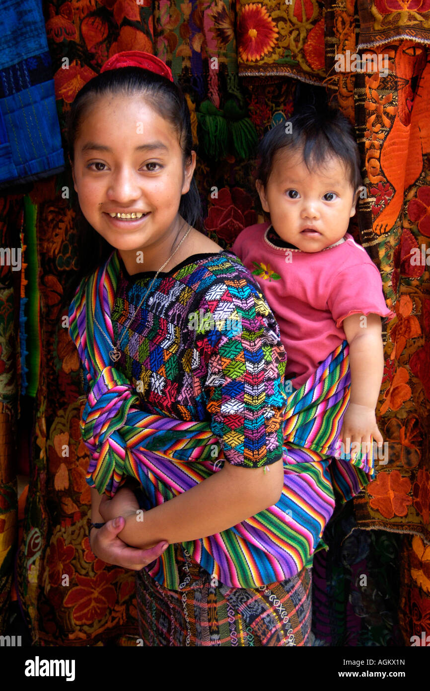 Guatemala, Chichicastenango, Maya, fille guatémaltèque en robe colorée  exerçant son enfant en écharpe sur le dos Photo Stock - Alamy