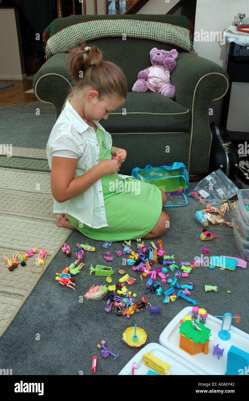 Fille joue avec des poupées miniatures Banque D'Images