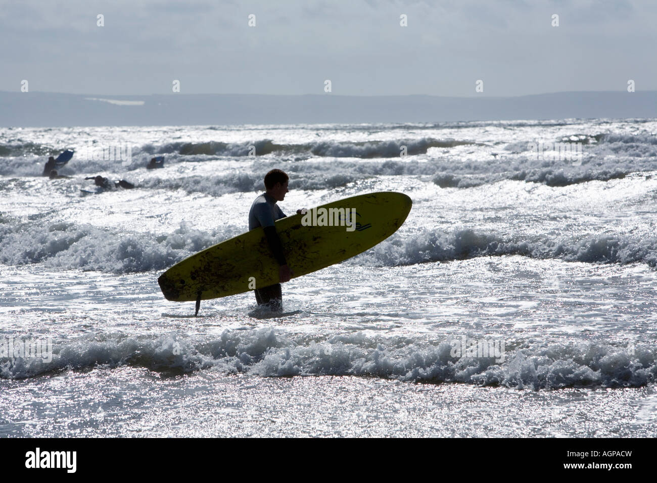 Surfer holding planche de surf à la baie de Croyde Devon, Angleterre Banque D'Images