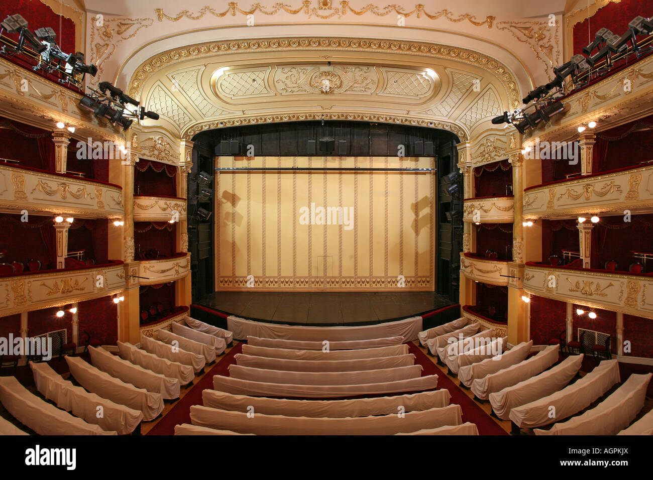 Scène de théâtre avec rideaux de protection de l'or et de chaises vides au premier plan Banque D'Images