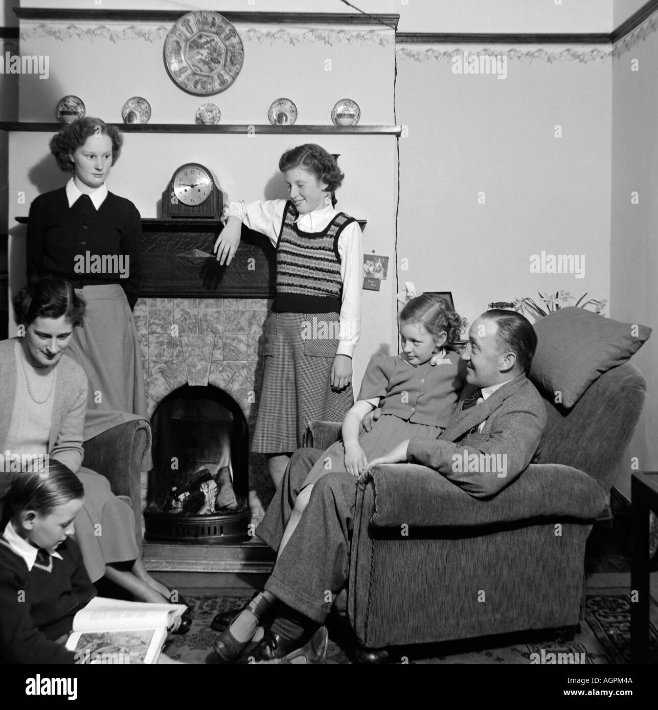 OLD VINTAGE SNAPSHOT PHOTO DE FAMILLE PÈRE MÈRE ET QUATRE ENFANTS DANS LE SÉJOUR DE DÉTENTE DE CHAMBRE 1950 Banque D'Images