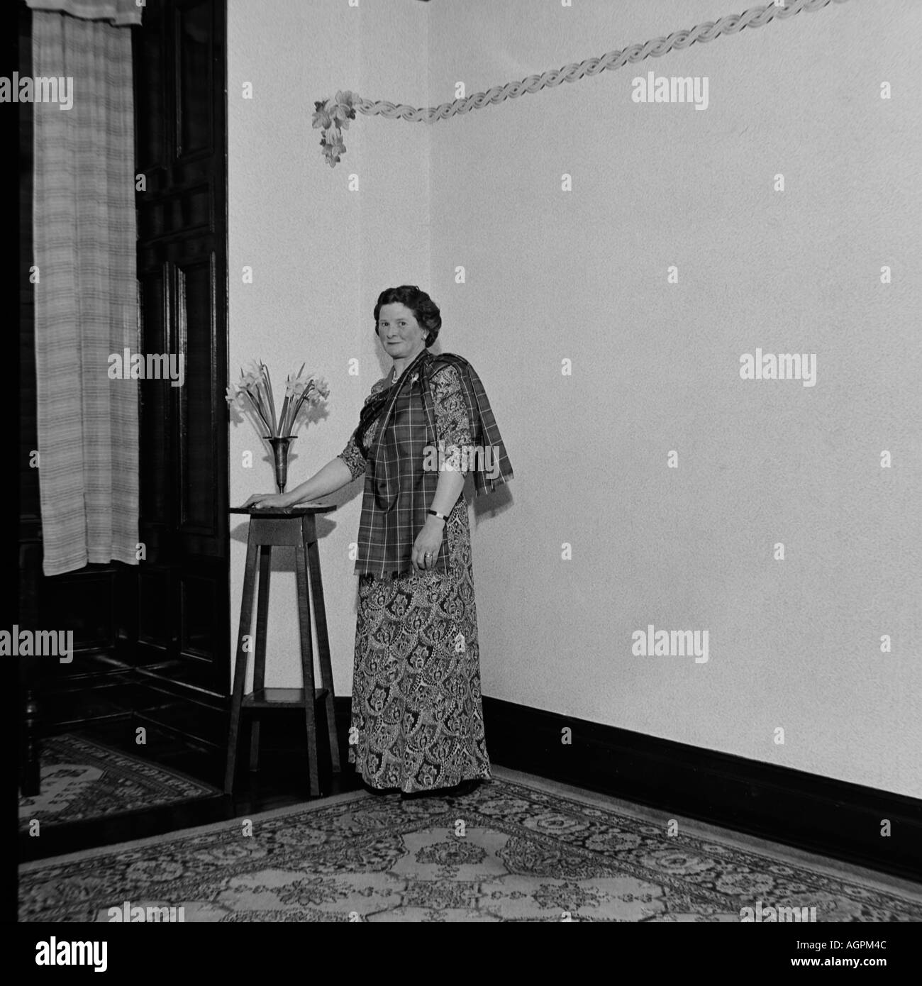 OLD VINTAGE SNAPSHOT FAMILLE PHOTOGRAPHIE DE FEMME PORTANT ROBE ET CHÂLE à motifs tartan debout dans la pièce vers 1950 Banque D'Images