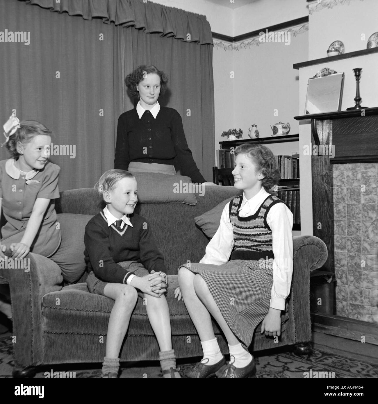 OLD VINTAGE SNAPSHOT FAMILLE PHOTOGRAPHIE DE TROIS JEUNES FILLES ET jeune garçon dans la salle de séjour vers 1950 Banque D'Images