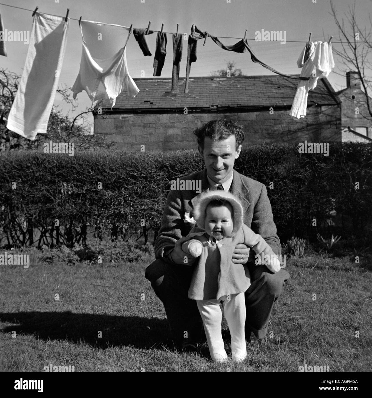 OLD VINTAGE SNAPSHOT PHOTO DE FAMILLE PÈRE jouant avec sa petite fille À JARDIN DE LA MAISON AVEC LAVE-LINE EN ARRIÈRE-PLAN : Banque D'Images