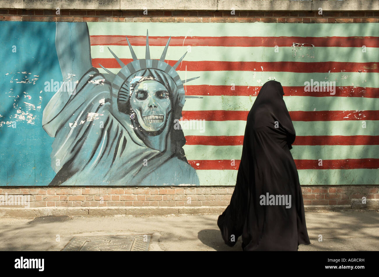 Une femme en tchador islamique (hijab) Balade en face d'un dégradé de la statue de la liberté et de l'USA flag sur les murs extérieurs de la Banque D'Images