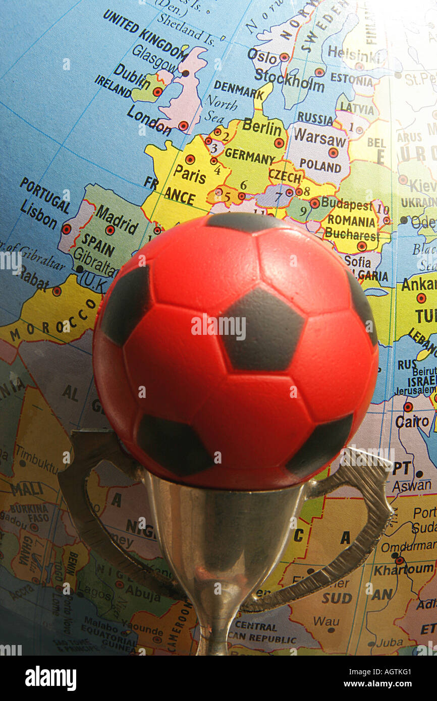 SSK79588 petite tasse du métal et rouge et noir bille en caoutchouc de soccer ou de football sport avec world globe en arrière-plan Banque D'Images