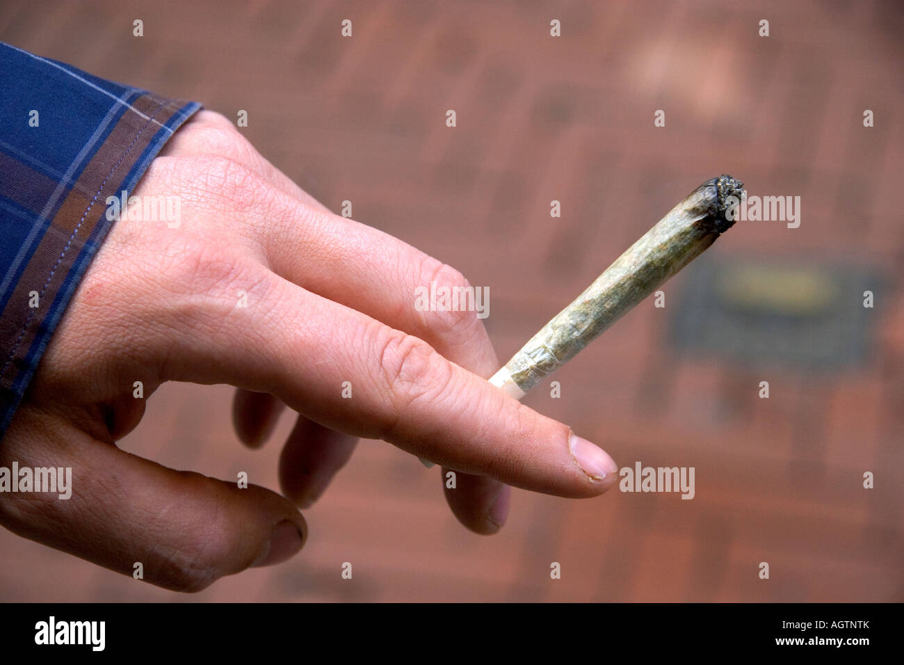 Main tenant une cigarette de marijuana à Amsterdam Pays-Bas Banque D'Images