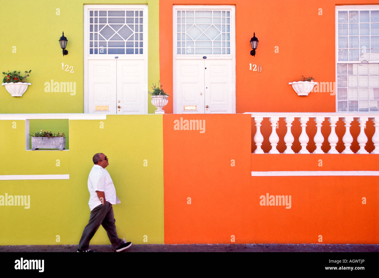 Un homme passe devant les murs pastel colorés des maisons dans le quartier de Malay (également connu sous le nom de Bo-Kaap) à Cape Town Afrique du Sud. Banque D'Images