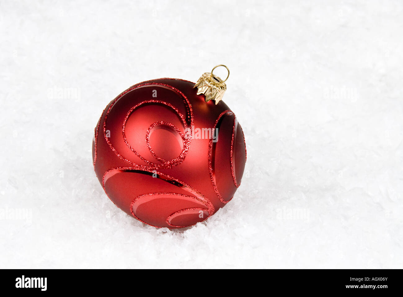 Ornement d'arbre de Noël rouge solitaire est assis dans la neige Banque D'Images