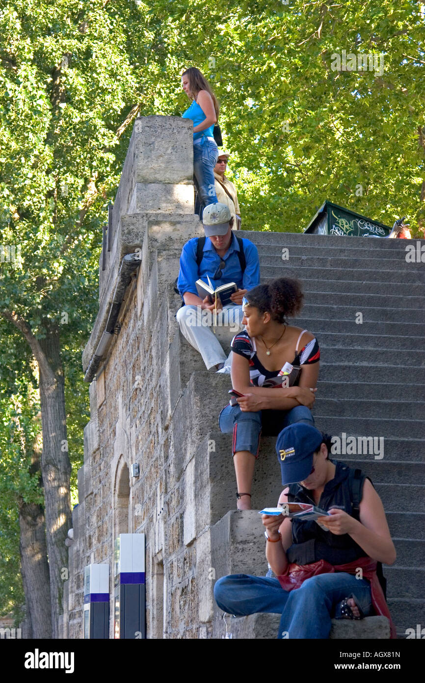 Les gens s'assoient sur les marches de pierre le long de la Seine à Paris France Banque D'Images