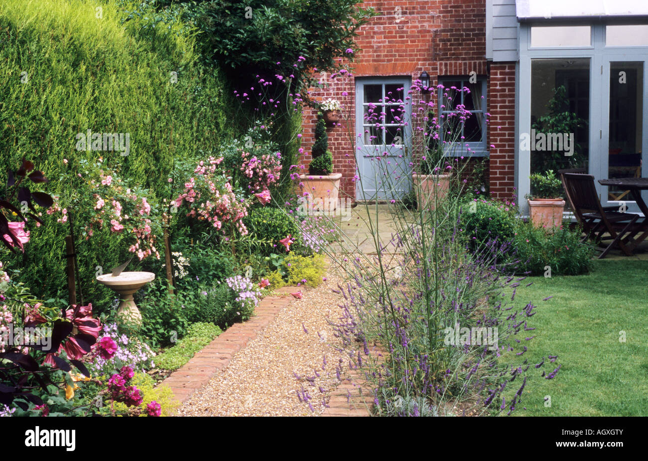 Chemin de gravier et petit jardin en brique Banque D'Images