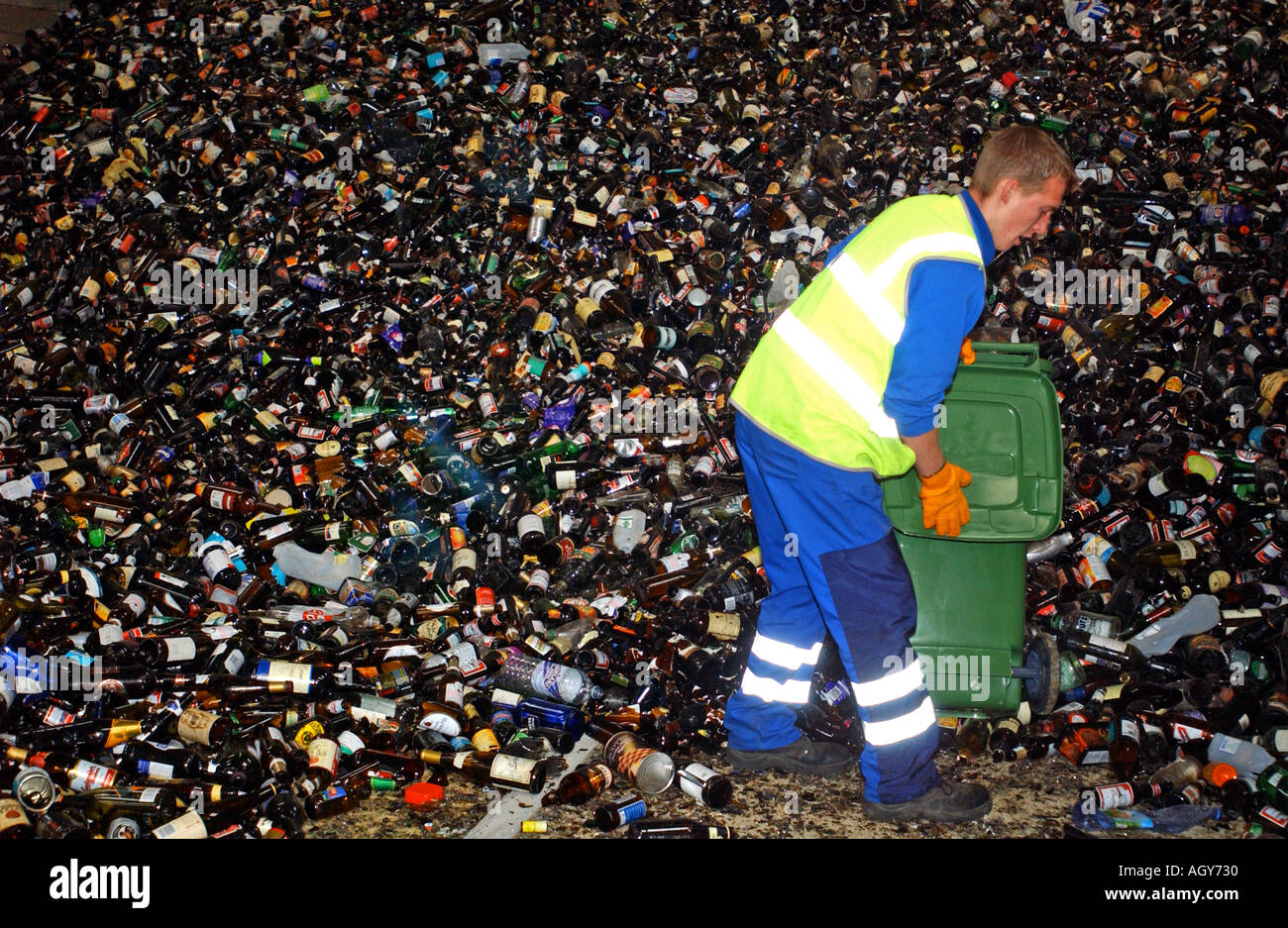 Un travailleur du Conseil de vider des bouteilles sur un centre de recyclage Banque D'Images