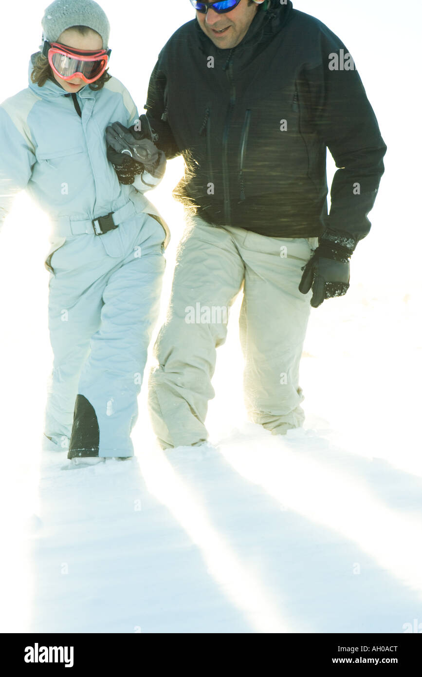 Père et fille dans la neige marcher ensemble, se tenir la main, cropped view Banque D'Images