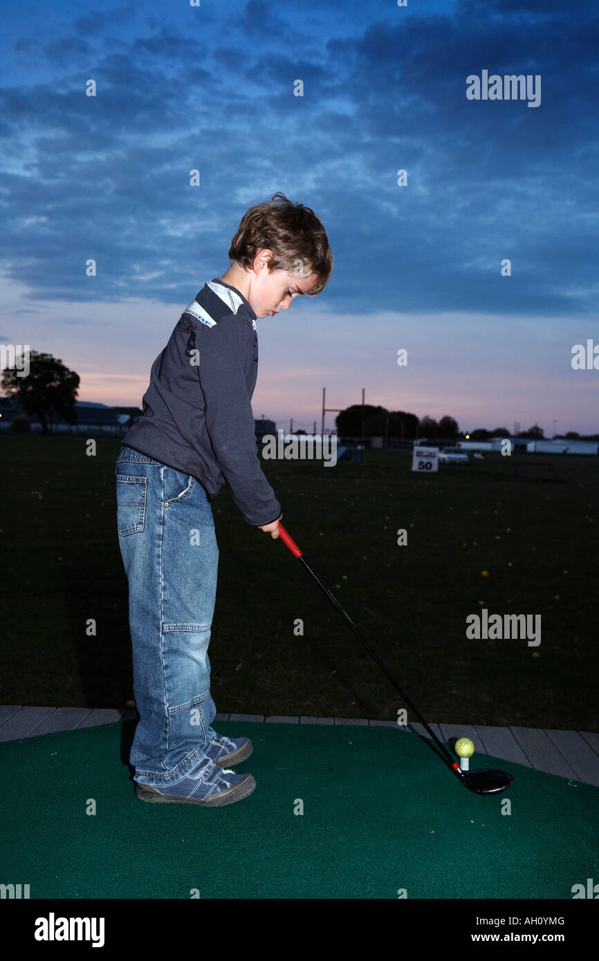 Boy 7 à la gamme de conduite à jouer au golf Banque D'Images