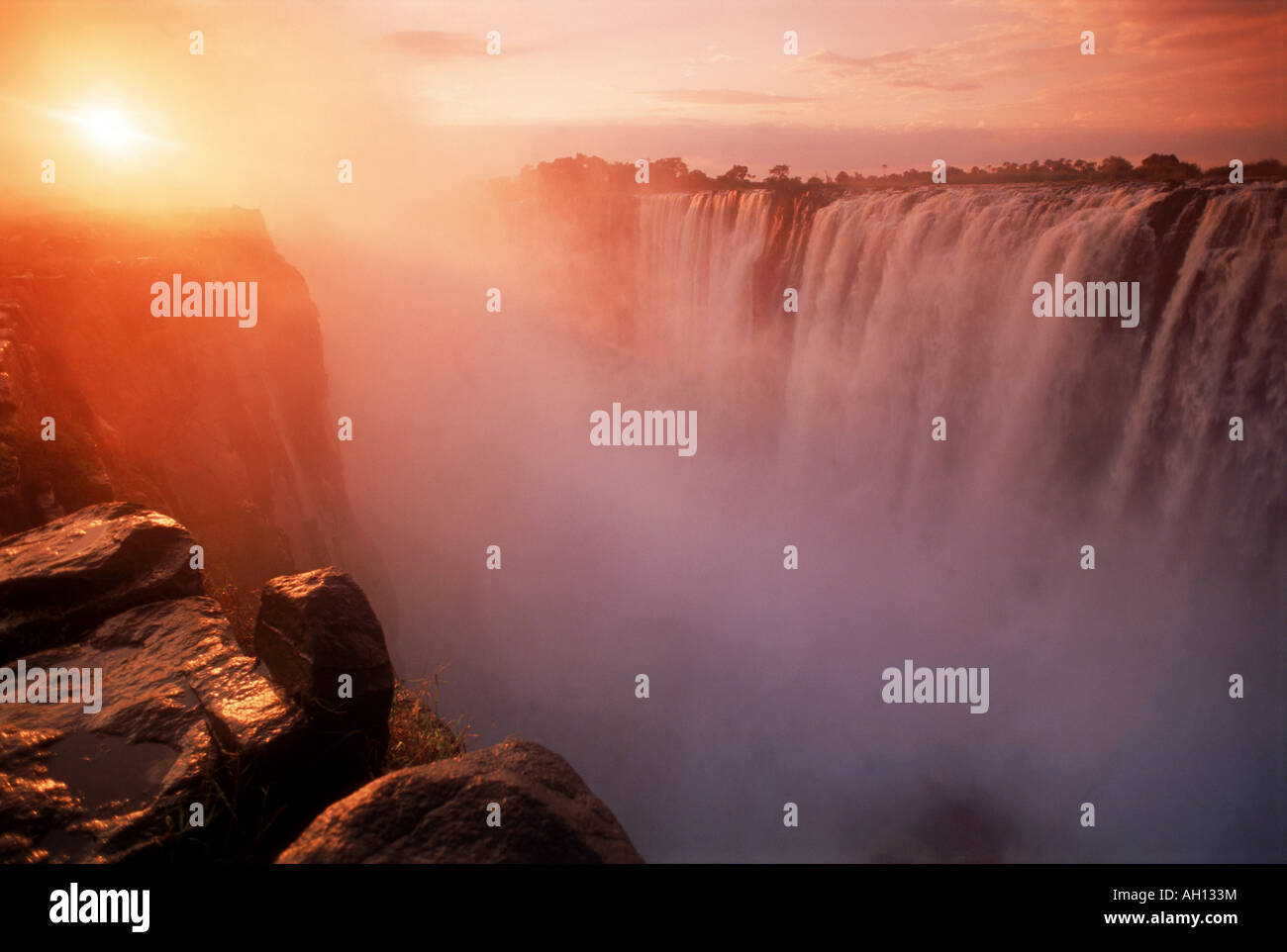 Lever de soleil à travers la brume sur la rivière Zambèze et les chutes Victoria, entre le Zimbabwe et la Zambie Banque D'Images