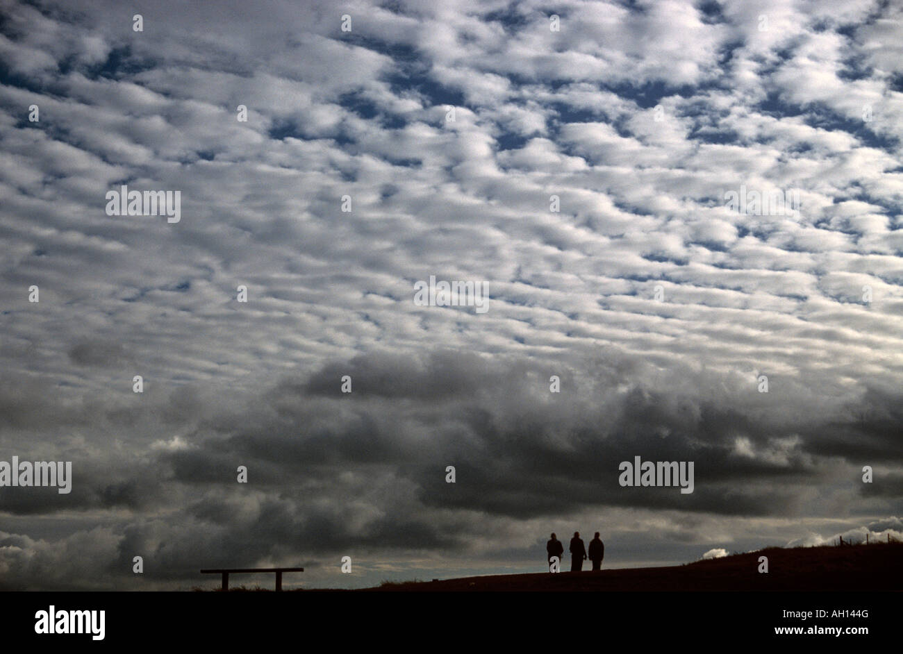 Trois personnes à pied sous les nuages Altocumulus (connu sous le nom de maquereaux ciel) Banque D'Images