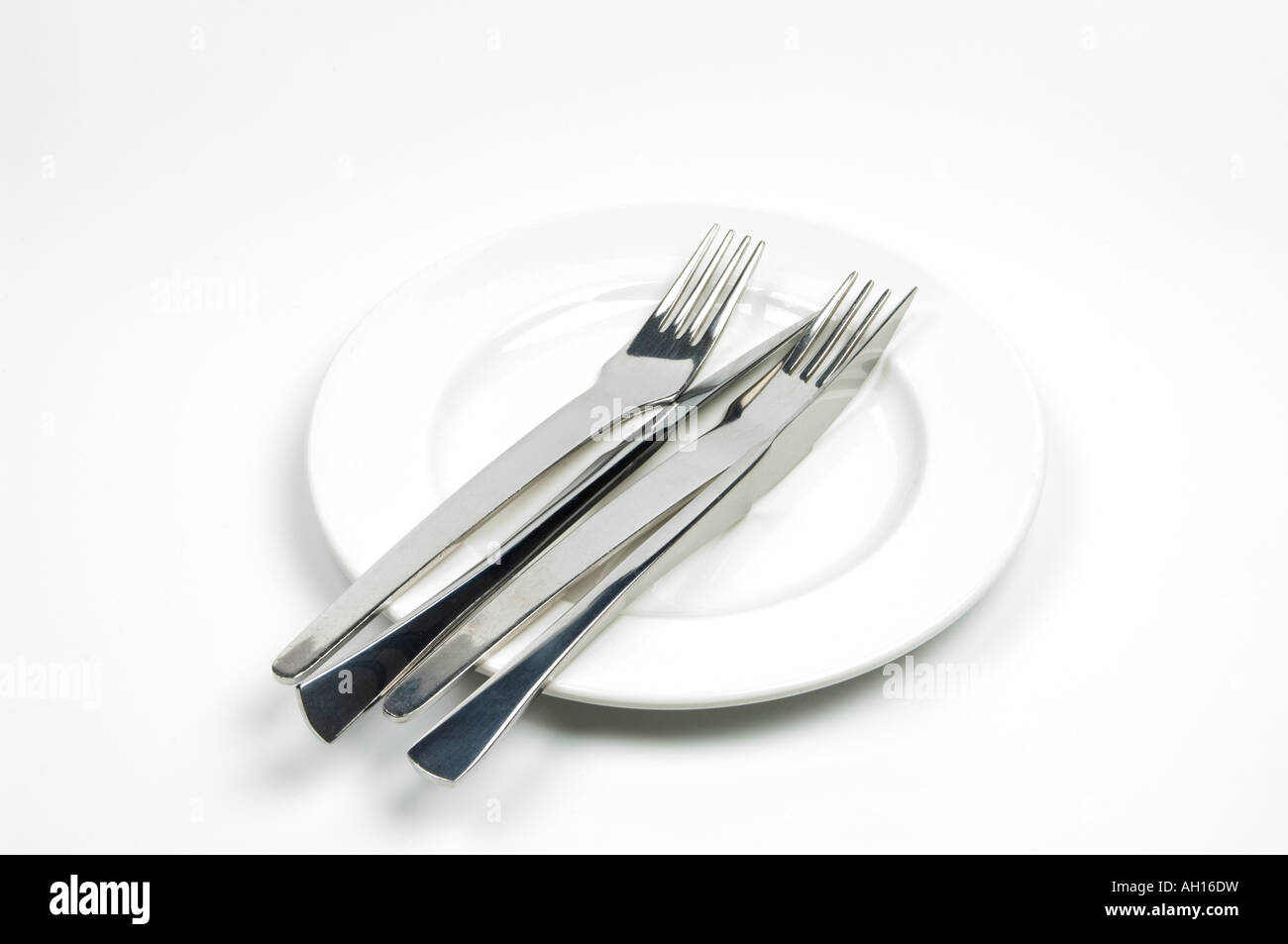 Couteaux et fourchettes sur une plaque blanche - régl. Banque D'Images