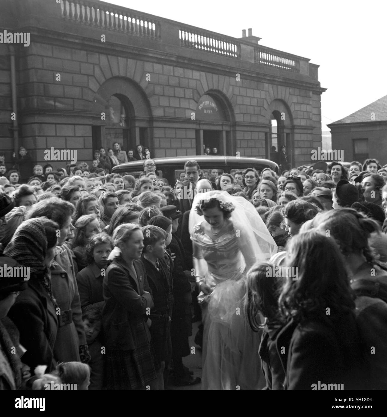 OLD VINTAGE SNAPSHOT FAMILLE PHOTOGRAPHIE DE mariée en satin blanc robe nuptiale MARCHE À TRAVERS grande foule À LA CÉRÉMONIE DU MARIAGE Banque D'Images
