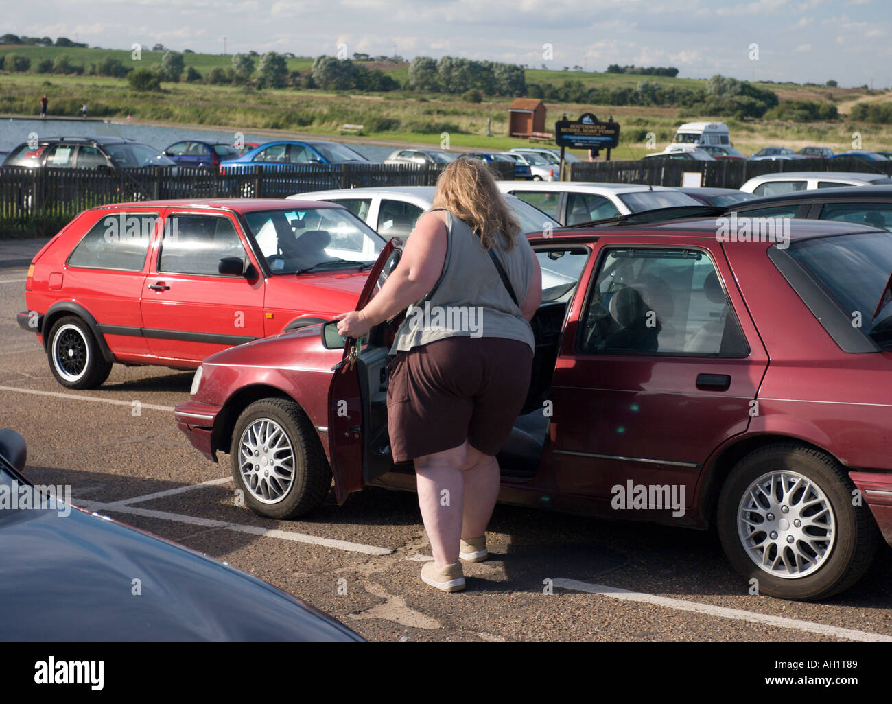 Vue arrière d'une grande femme d'entrer dans sa voiture Banque D'Images