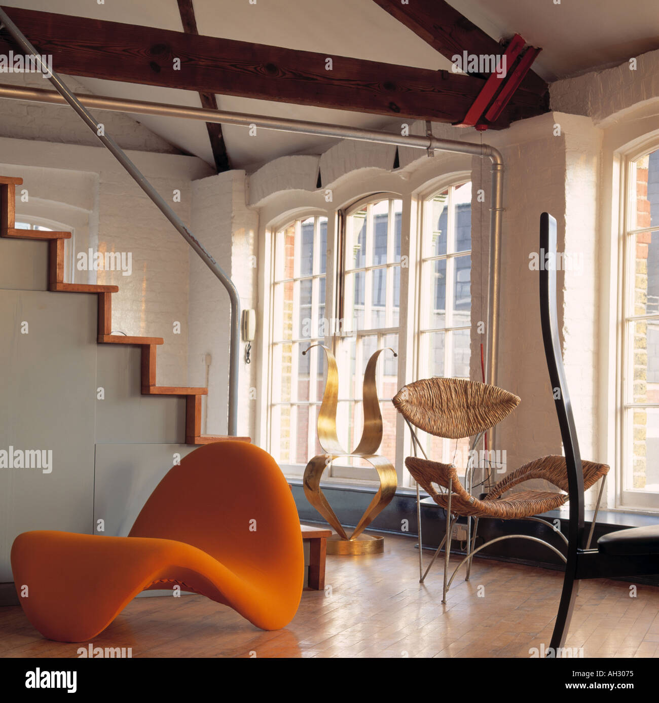 Pierre Paulin orange 'langue maternelle' chair in loft salon de conversion avec Tom Dixon chaises Banque D'Images