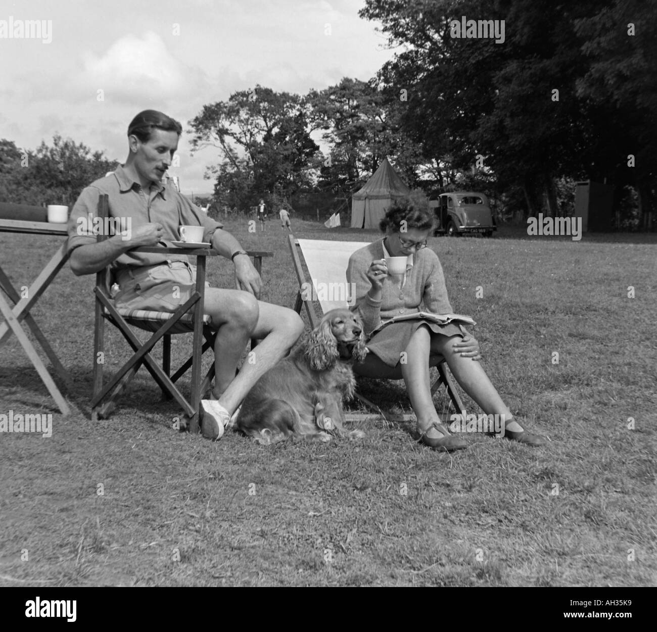 OLD VINTAGE PHOTO DE FAMILLE DE SNAP SHOT COUPLE ASSIS DANS DES TRANSATS SUR CAMP SITE VERS 1950 Banque D'Images
