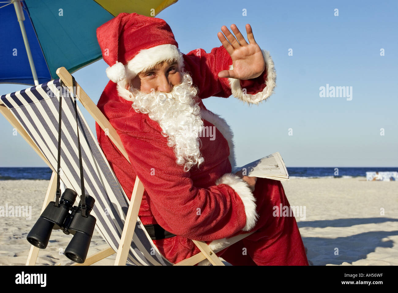 Plage de sable en plein air journee d eau mer dress deguisement pere noel Noel tradition pantalon chapeau jeune homme parapluie barbe Photo Stock Alamy