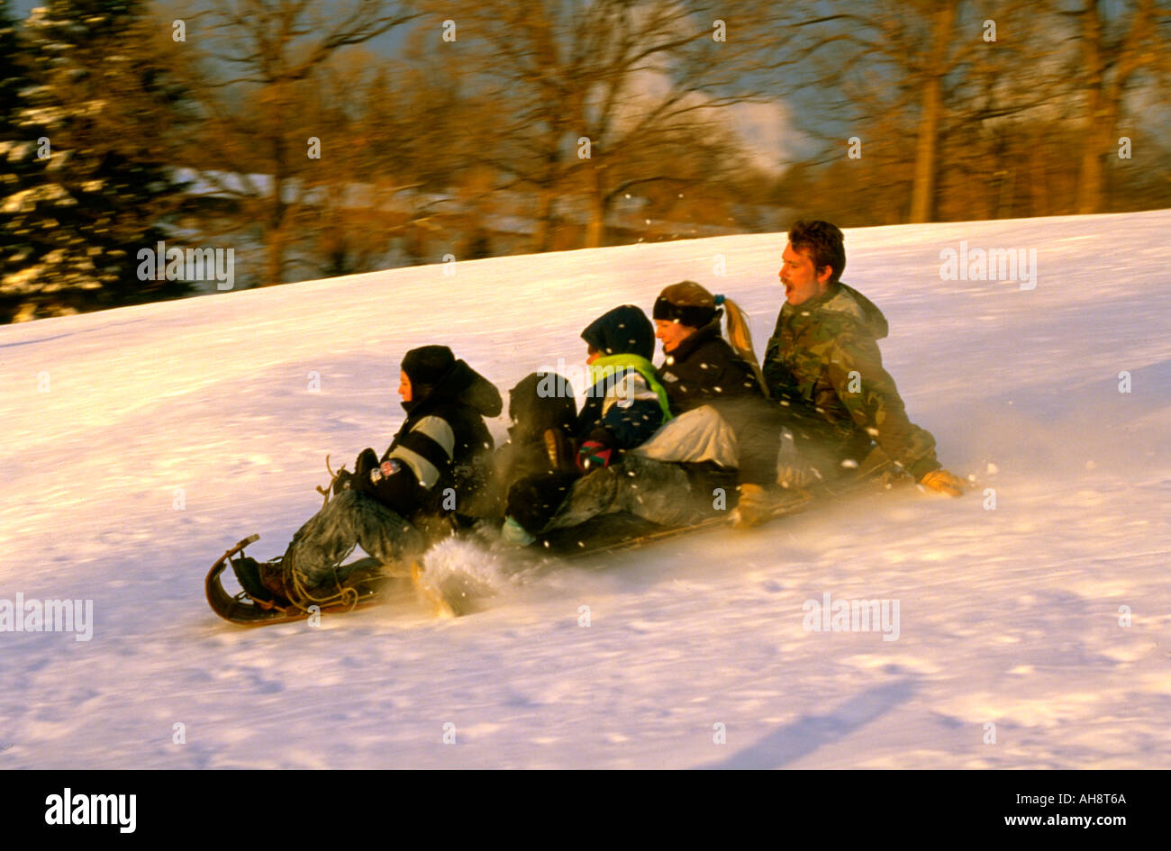 Family riding toboggan vers le bas de la ville et de la campagne de parcours de golf. St Paul Minnesota USA Banque D'Images