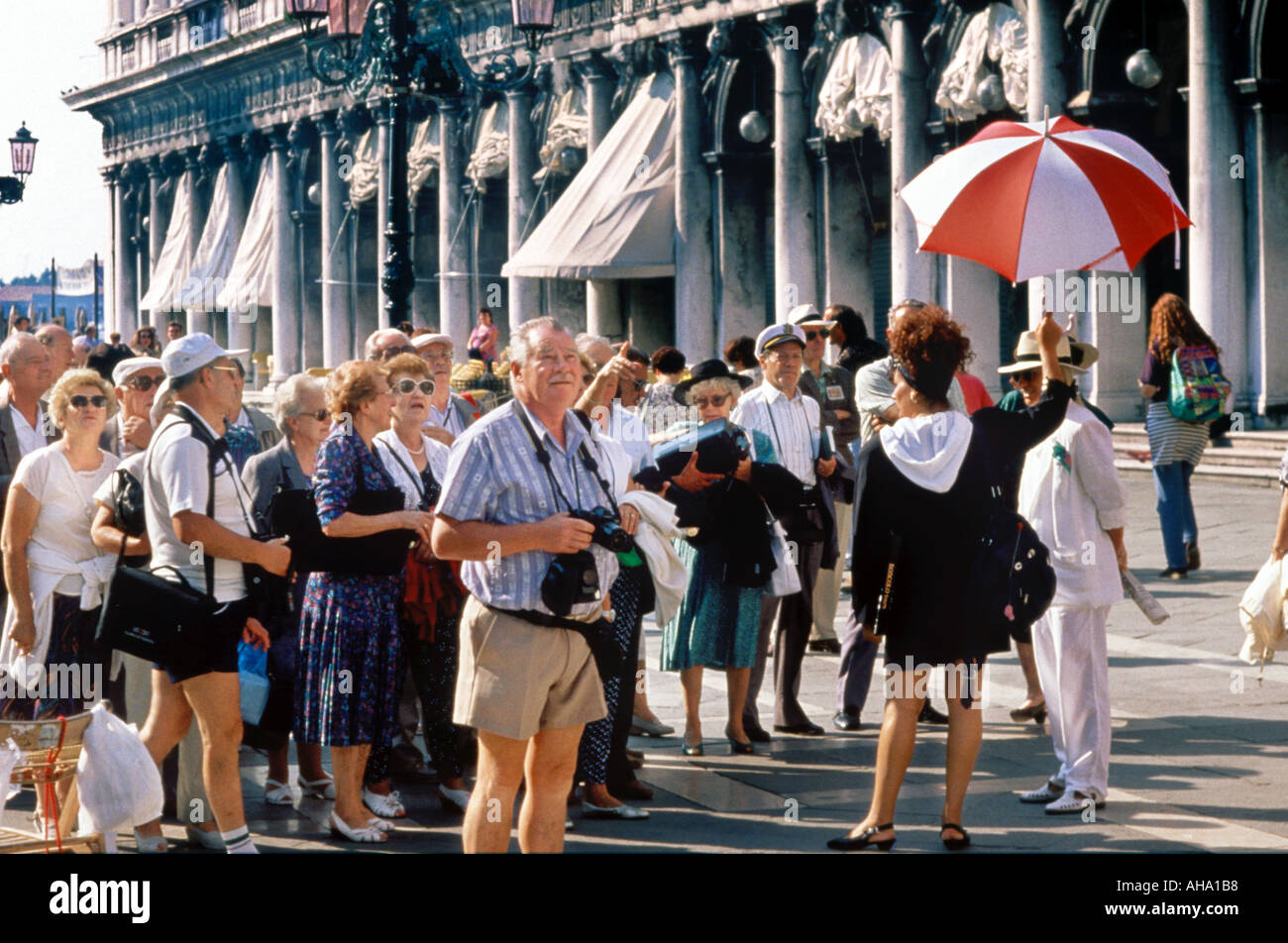 Les touristes À LA RETRAITE ET UN GUIDE SUR LA PIAZZA SAN MARCO Venise Italie Banque D'Images