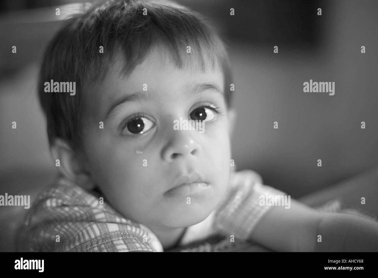 Head and shoulders portrait d'un jeune garçon avec la larme sur la joue à la tristement l'appareil photo Banque D'Images