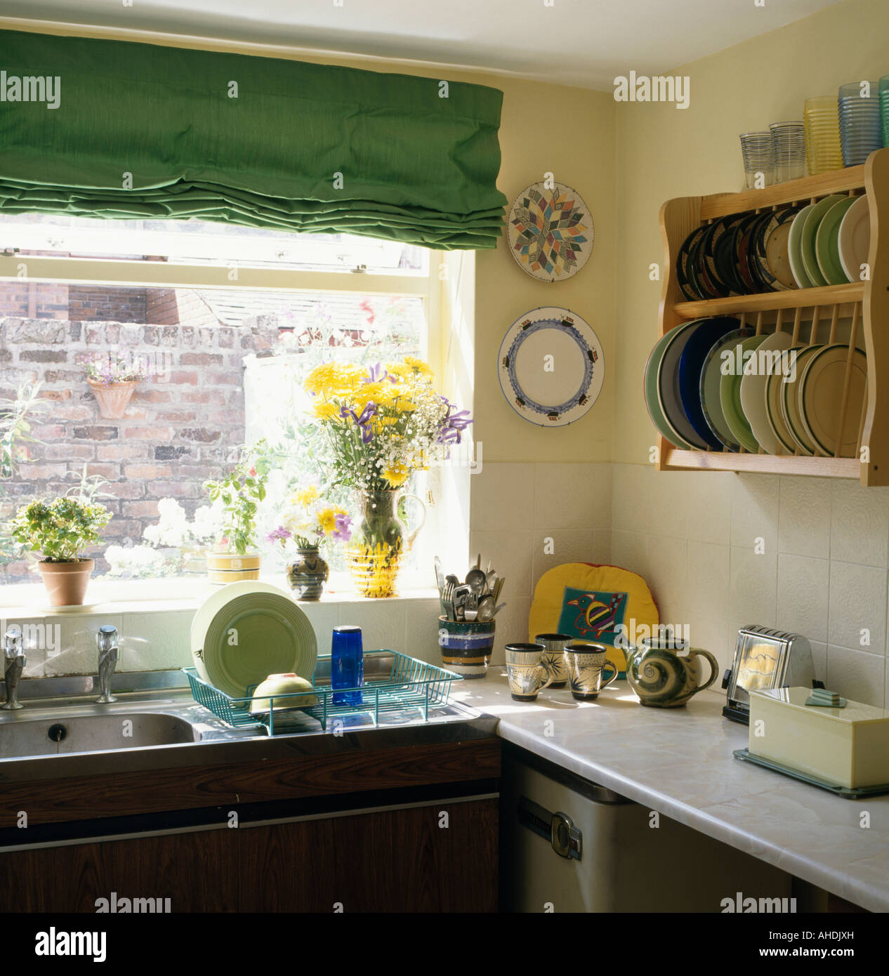 Aveugles Vert Au Dessus Evier En Acier Inoxydable Avec Egouttoir En Jaune Pastel Cuisine Avec Plaque Pin Rack Sur Le Mur Photo Stock Alamy