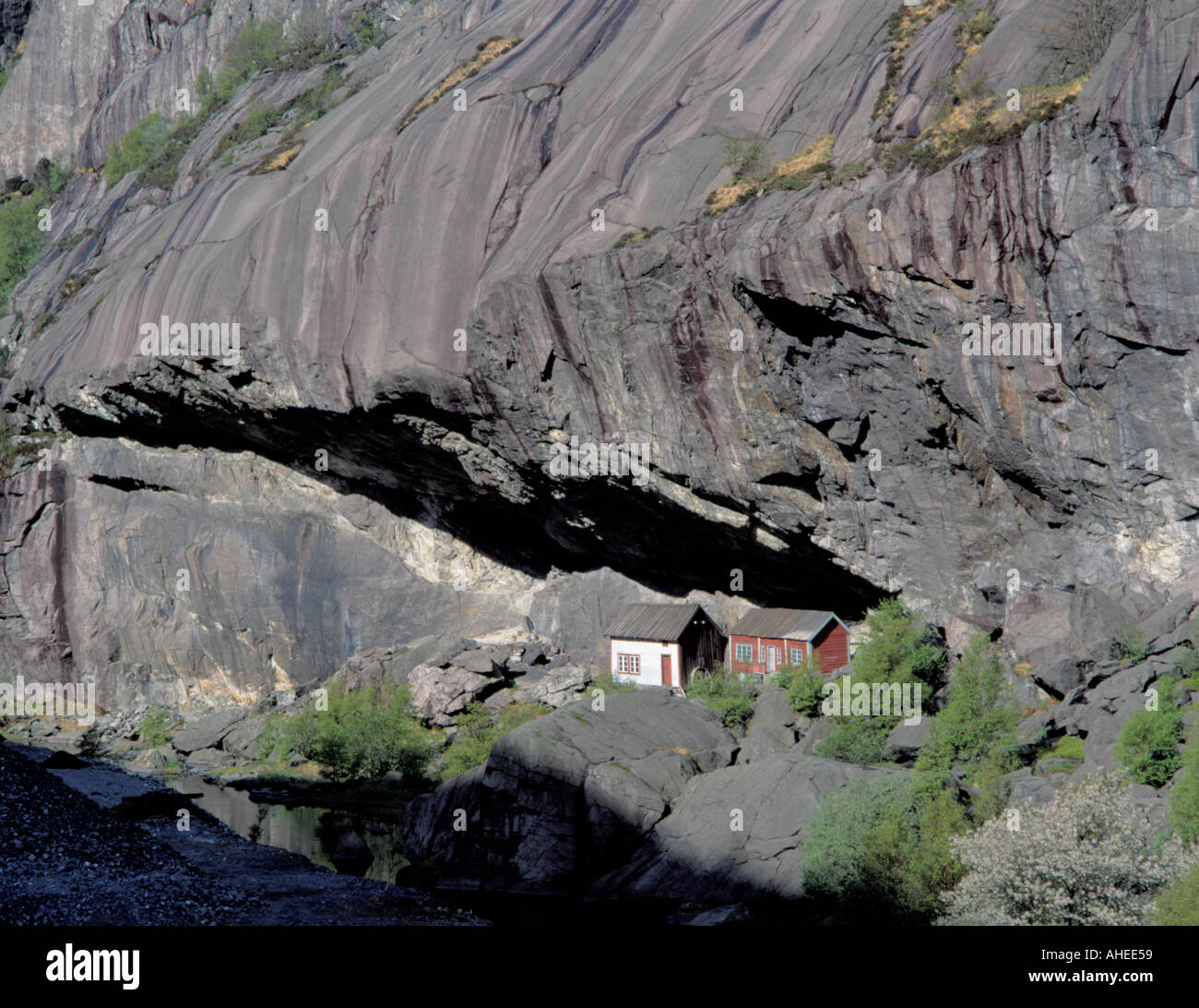 Maisons anciennes pittoresques sous 'Helleren' (un énorme rocher, déplacement) Jøssingfjord, Rogaland,. Banque D'Images