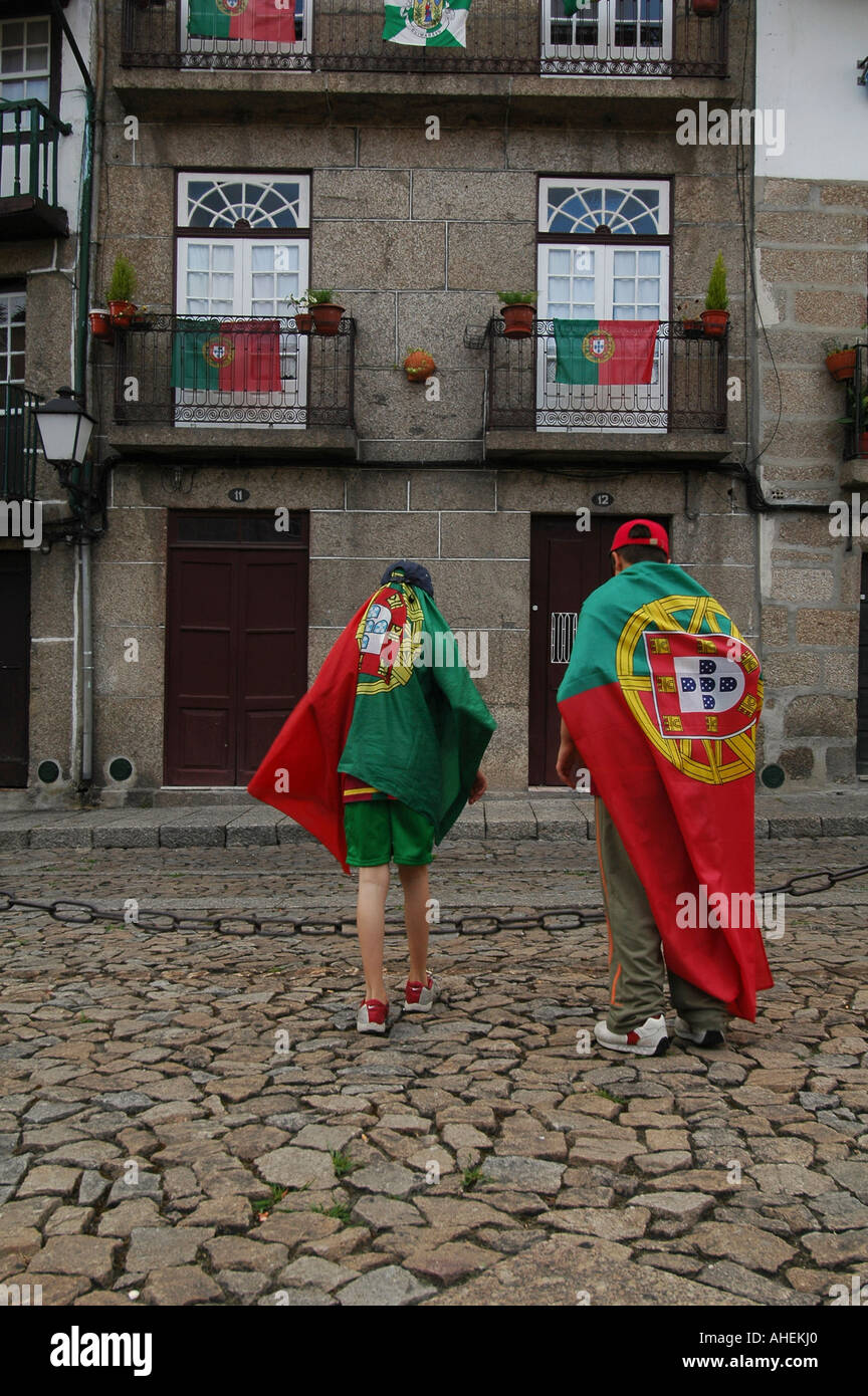 Les jeunes garçons plié avec drapeau national lors d'un match de football européen en vieille ville Portugal Guimaraes Banque D'Images