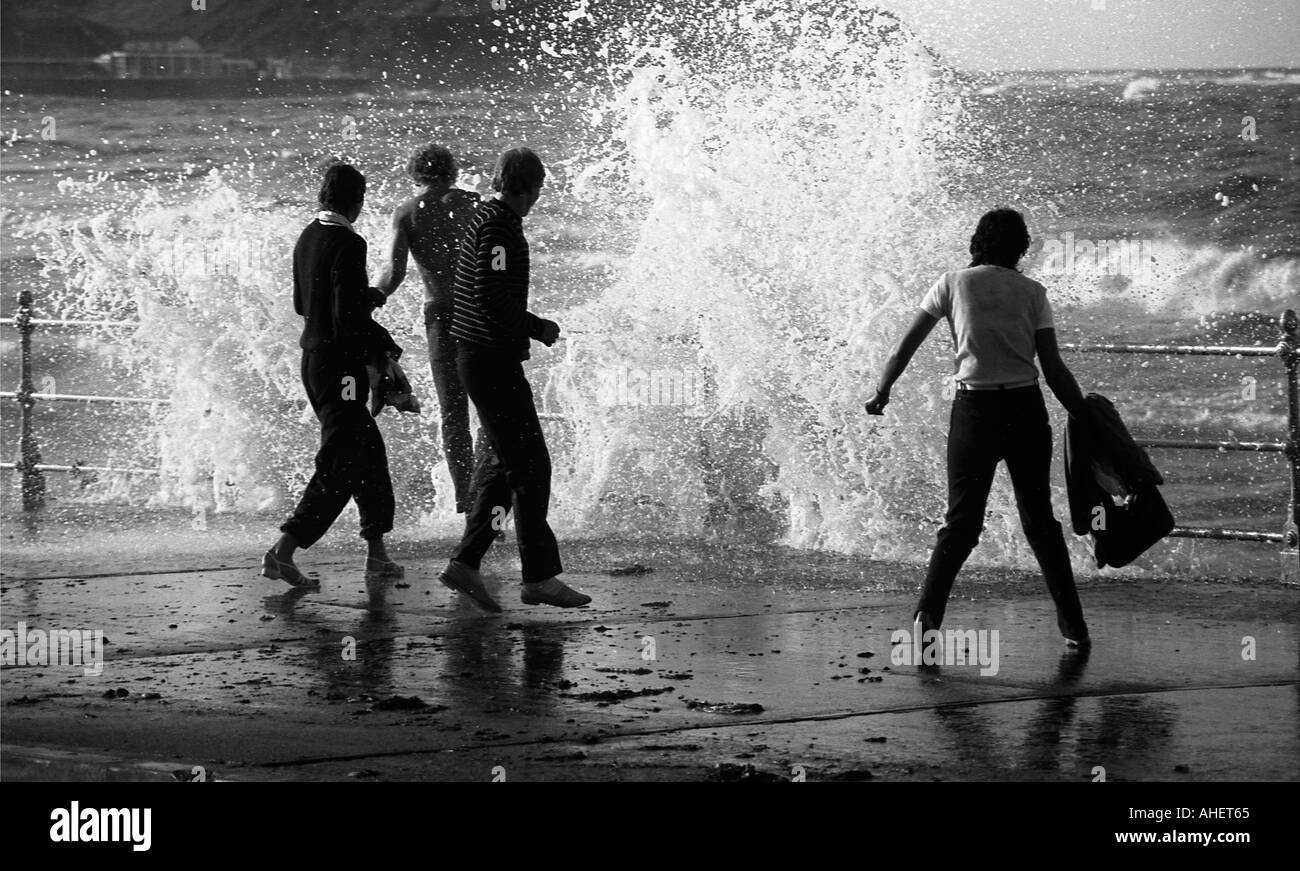 Les gens en esquivant de grosses vagues sur le front de mer à Scarborough Banque D'Images