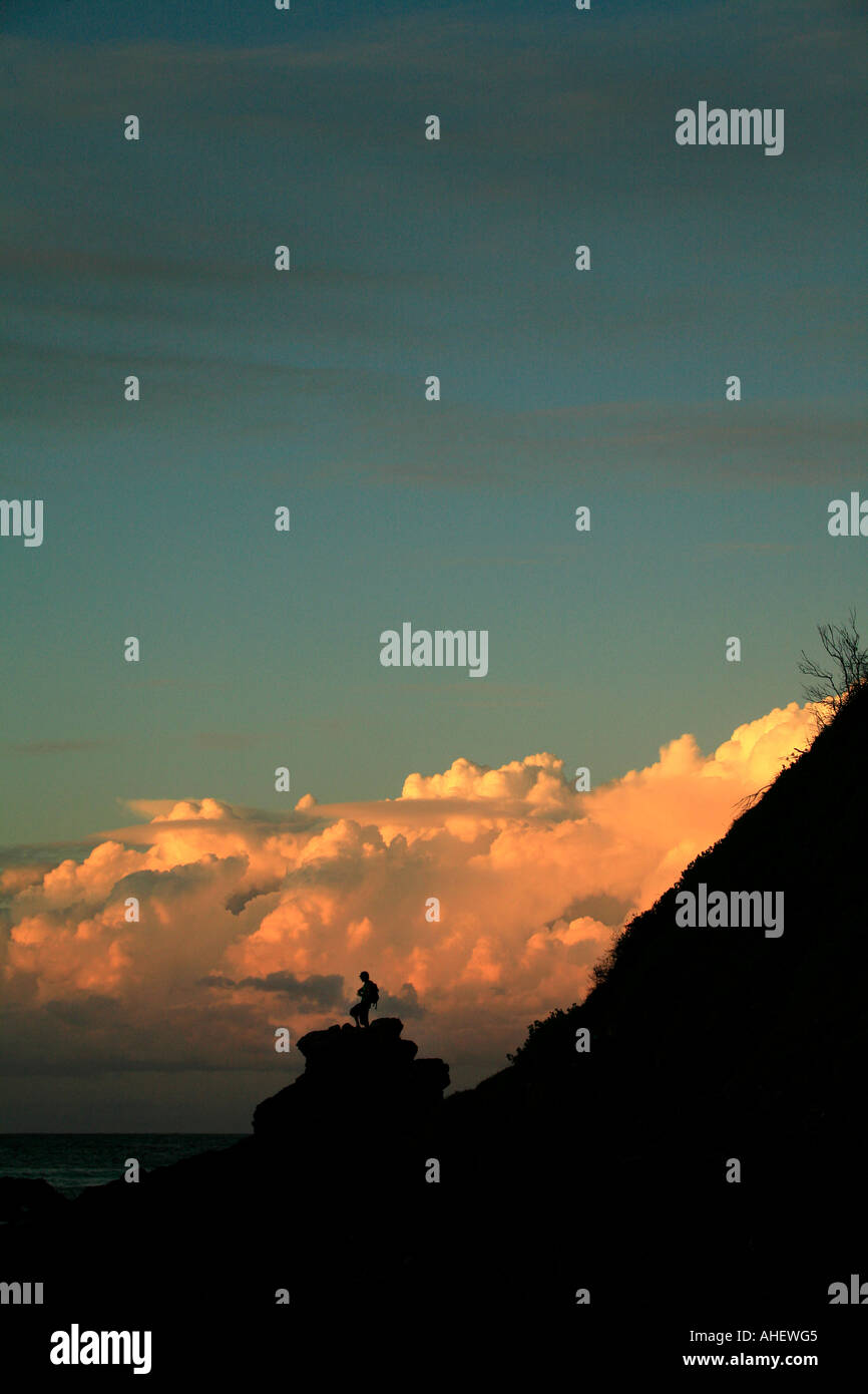 Les nuages et l'homme en silhouette au coucher du soleil plage de Wategos Byron Bay Banque D'Images
