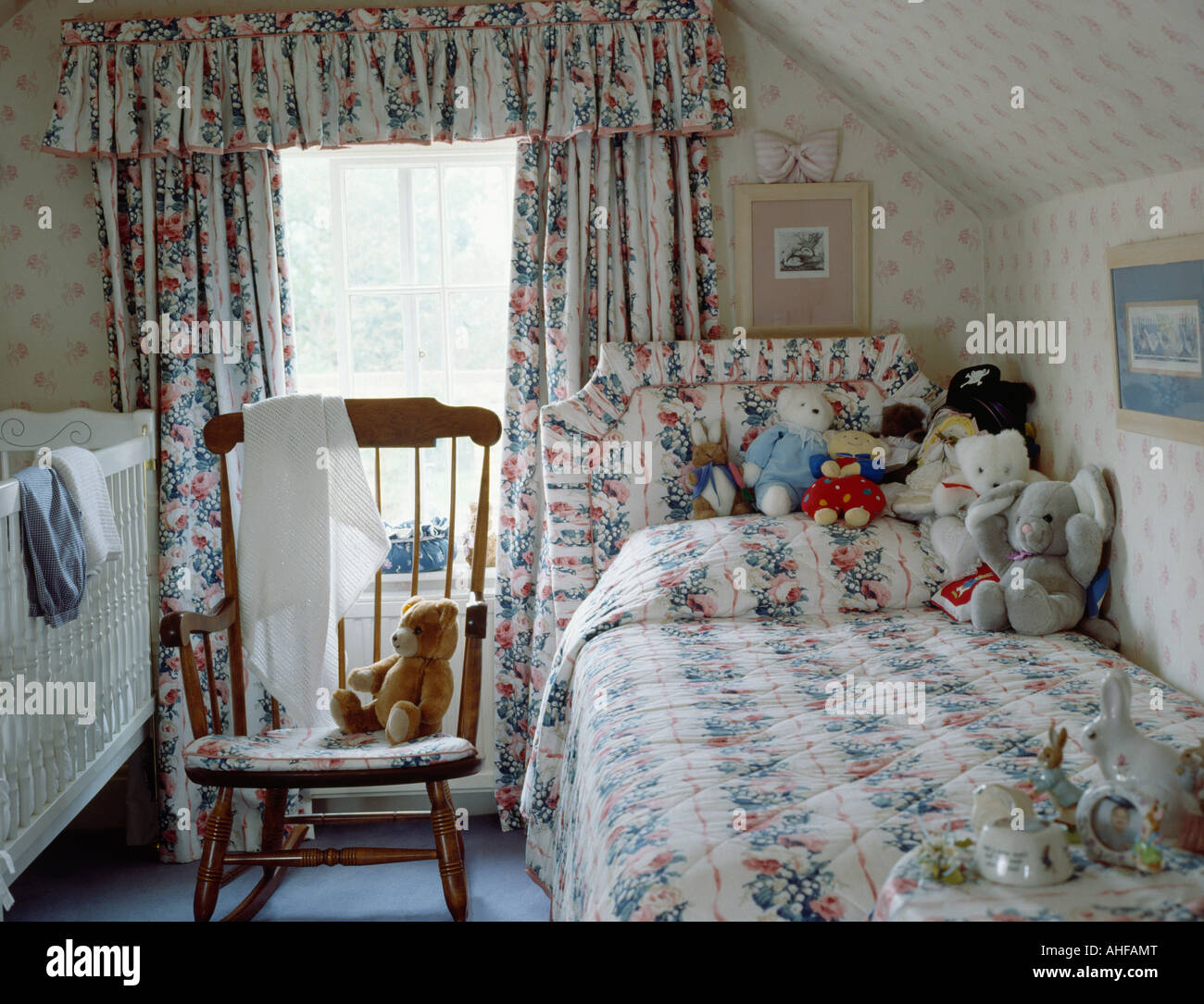 Le linge de lit à motifs fleuris et des rideaux assortis childs chambre  mansardée avec lit bébé et lit simple Photo Stock - Alamy